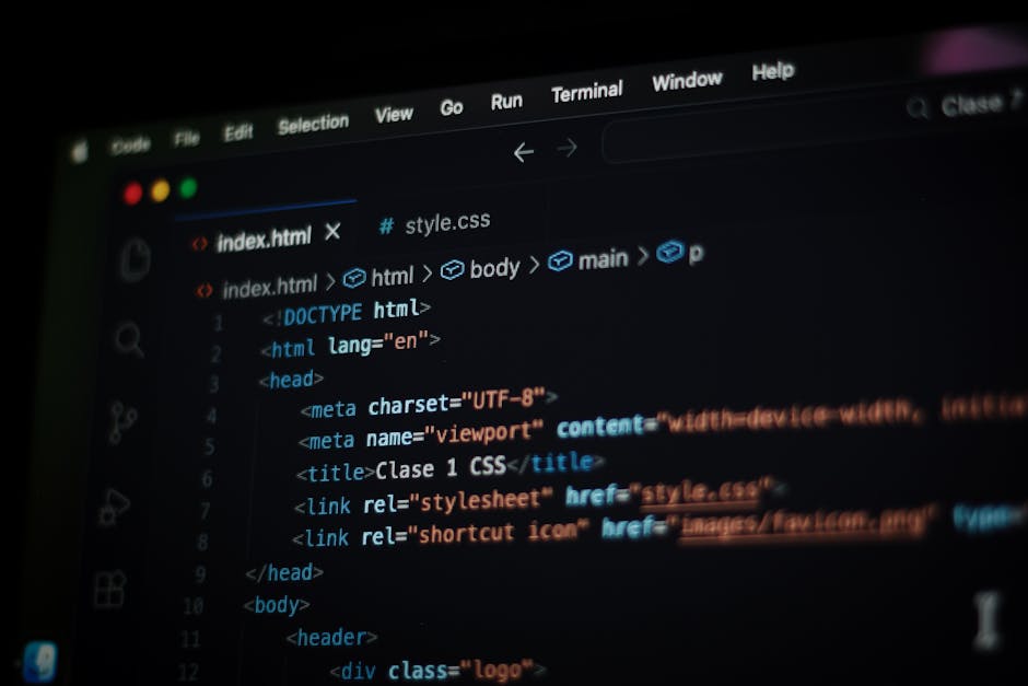 A computer monitor displaying HTML and CSS code in a dark-themed code editor. The code includes tags like <html>, <head>, <title>, and <link>, with syntax highlighting in various colors. The screen sh